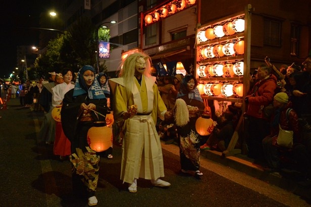 【写真を見る】独特なキツネの面を付けた人の姿も