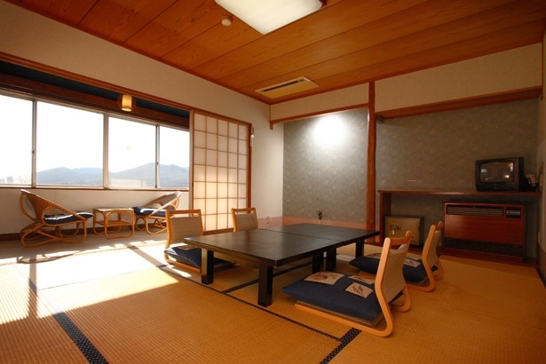 【写真を見る】大島温泉ホテルの部屋の一例、10畳和室。山側は広大な樹海と三原山が、海側は太平洋、伊豆半島、富士山が望める