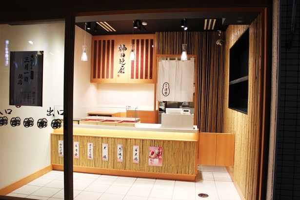 店内、左奥には「神田達磨」の店名とともに小豆の入った木製のディスプレイが飾られている