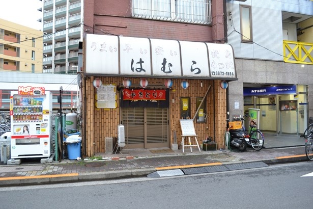 看板に書かれた「うまい 早い 安い」の文字を見て内海は「いいですねぇ～」とニヤリ(「大衆酒蔵はむら」)