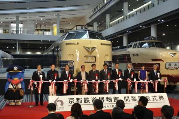 京都鉄道博物館開業記念式典のテープカットの模様。京都市の門川大作市長や俳優の西村和彦さんらもお祝いに駆けつけた。左端は同館の公式キャラクター・ウメテツ
