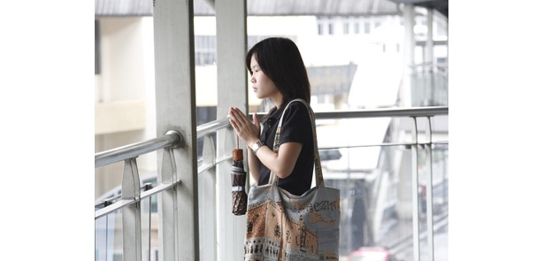スカイウォークから祈る少女。タイの人々は神を敬うことを常に忘れない