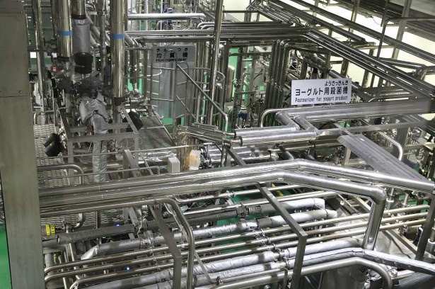見学は2階の通路から下を見下ろす。複雑に入り組んだ配管の中にはヨーグルトが流れている