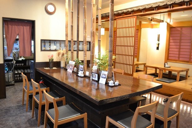 巧と本山が座った中央の大テーブルは、竹のあしらいが印象的(「蕎麦処ささい」)