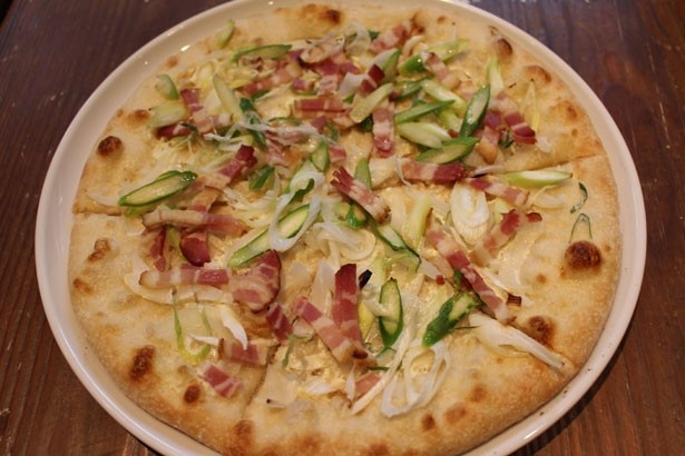 「ベーコン、季節野菜、グリーンアスパラガスのレモン風味タルトフランベ」(1300円)。レモンの風味が爽やかな薄焼きのピザ