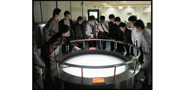 屋上の望遠鏡から取り込んだ太陽の光をスクリーンに映して観測する