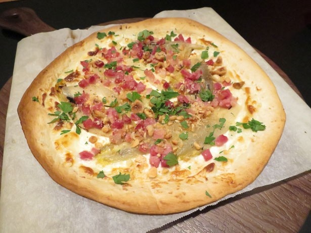 「ジャンボンブランとチコリーとヘーゼルナッツのタルトフランベ」800円。ボイルハムやチコリーを乗せた薄焼きピザ