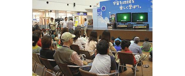 徐々に進む日食に会場は固唾をのんで見守る雰囲気に
