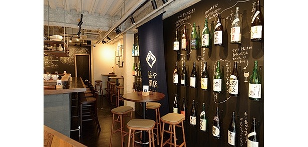 スタンディング席、カウンター席、テーブル席があり、店内には壁一面に日本酒が並ぶ/益や酒店