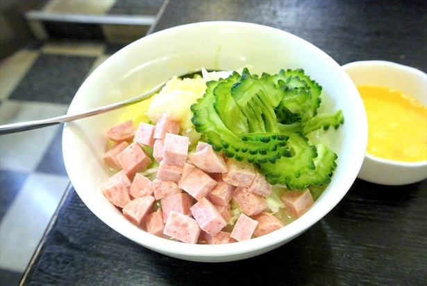 【写真を見る】ゴーヤのほろ苦さと最後に加える卵が決め手の「ゴーヤもんじゃチャンプル風」(荒川ハイサワーセット1030円)は、南千住「麦の市」で提供される