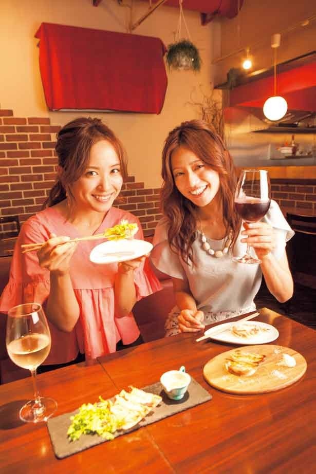 餃子を食べる武田訓佳さん(左)とワインを片手に持つ斉藤雪乃さん(右)