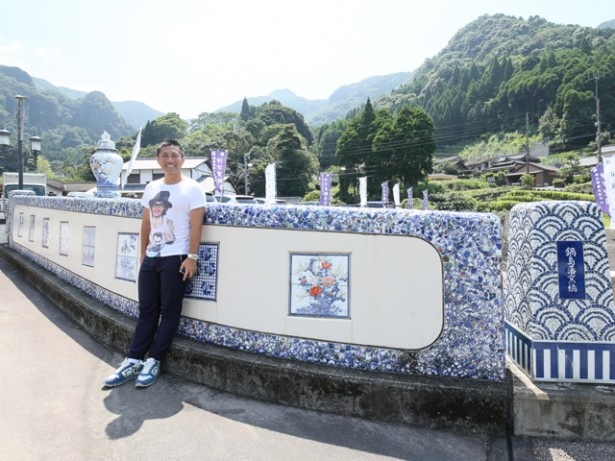 【写真を見る】陶板と無数の陶片が施された鍋島藩窯橋。欄干の外側には100枚以上の陶板で竜と鳳凰(ほうおう)が描かれている
