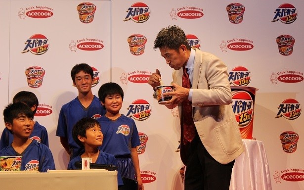 【写真を見る】新テレビCM発表会で美味しそうにラーメンを食べる三浦知良さん