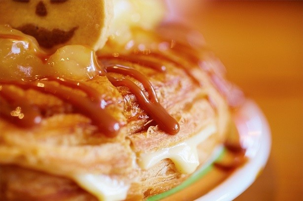 【写真を見る】甘いキャラメルソースがかかったデニッシュパンの間にはとろっと溶け出すカスタードクリームをサンド