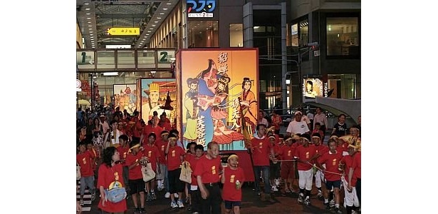 8/22（土）18：30からのパレードでは、横山光輝の ｢三国志｣に登場する武将を描いた灯籠3基が子供たちに引かれて商店街を回る