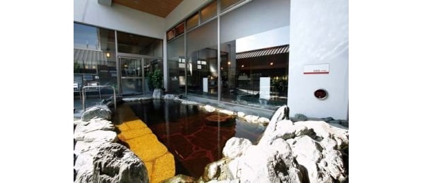 天然温泉 満天の湯の「岩風呂」。施設の地下から湧く褐色の温泉を楽しめる露天の天然温泉