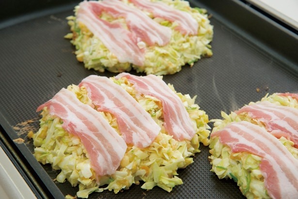 【写真を見る】ホットプレートの上で作られるお好み焼き