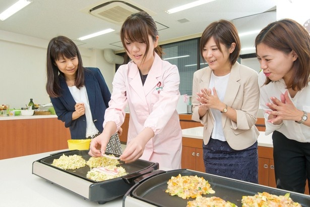 お好み焼き士の肩書きをもつオタフクソースの女性社員が慣れた手つきで調理