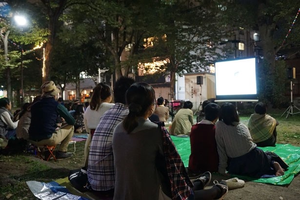 ブルーシートや椅子に腰かけるなど、思い思いのスタイルで映画を楽しむ観客