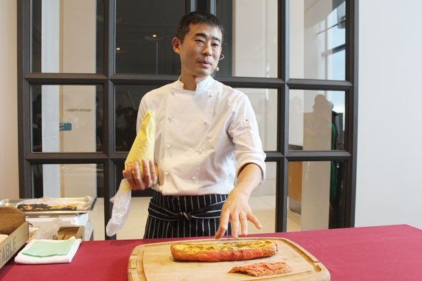 「エクレアケーキ」(税抜3000円)のデモンストレーションを行う、岡崎正輝シェフ