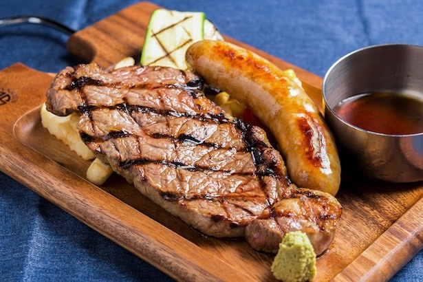 毎日20食限定の「サービスサーロインステーキランチ」写真は極太ソーセージトッピング。