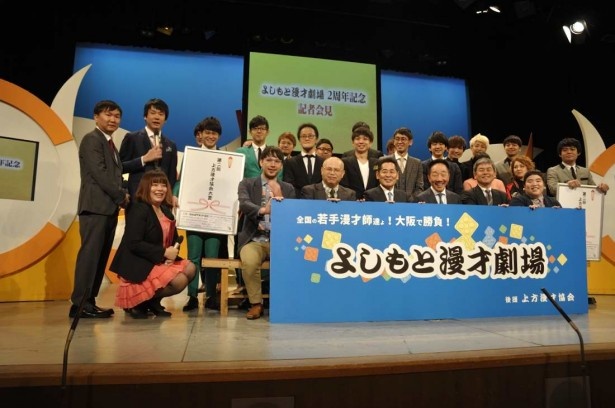 中田カウスボタンを中心に、記念撮影に応える若手芸人と関係者たち