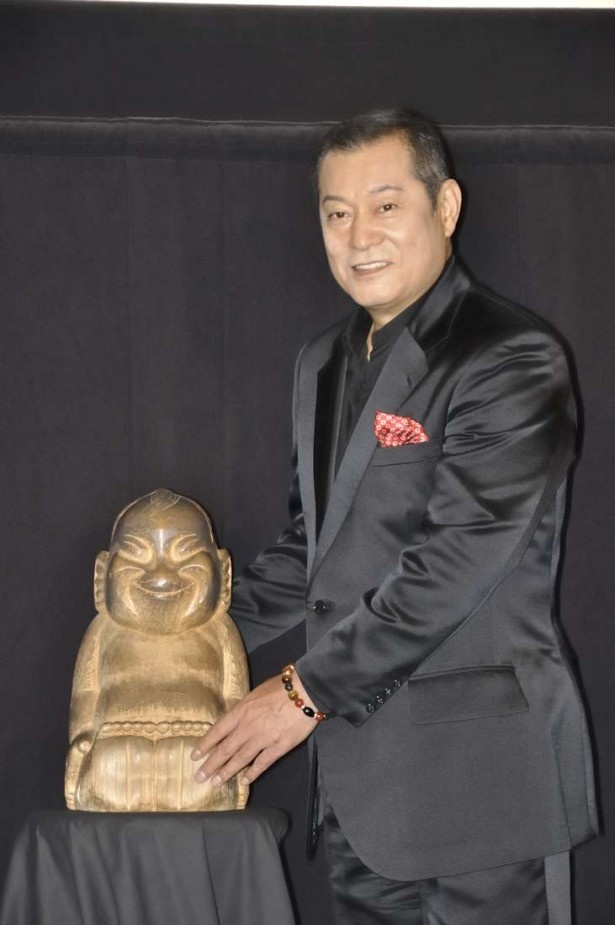 ビリケンさんとツーショットで記念撮影に答える松平健。元々浅草にあった「ルナパーク」が火災で焼け、大阪に再建された。その際、ビリケンさんが設置された