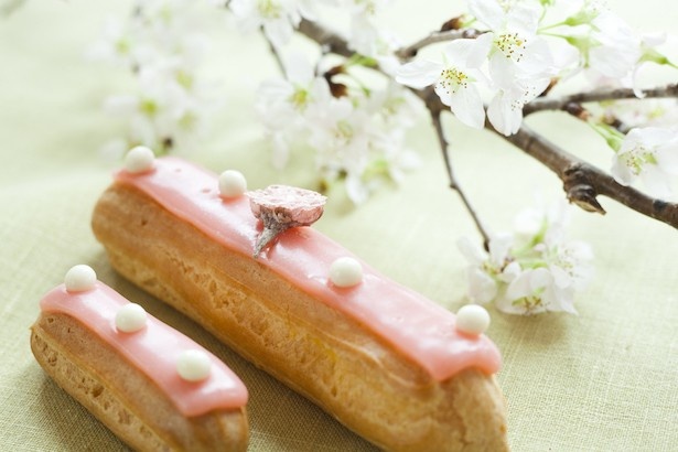 シグネチャーアイテムであるエクレアが、桜フレーバーで再登場！ 桜のリキュールの香りと、カスタードクリーム、上に載せたホワイトチョコのクランチの食感を楽しめる